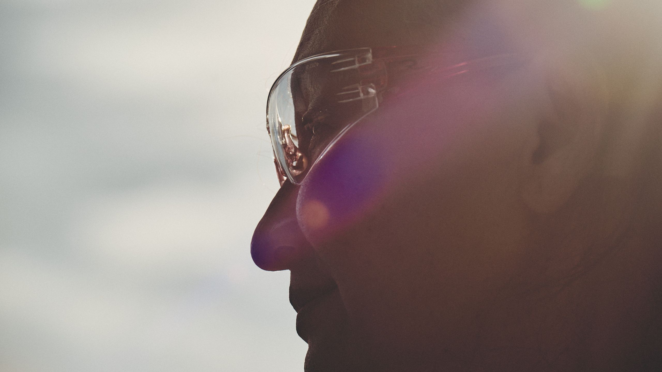 Profile portrait of a worker in clear safety glasses, softly lit