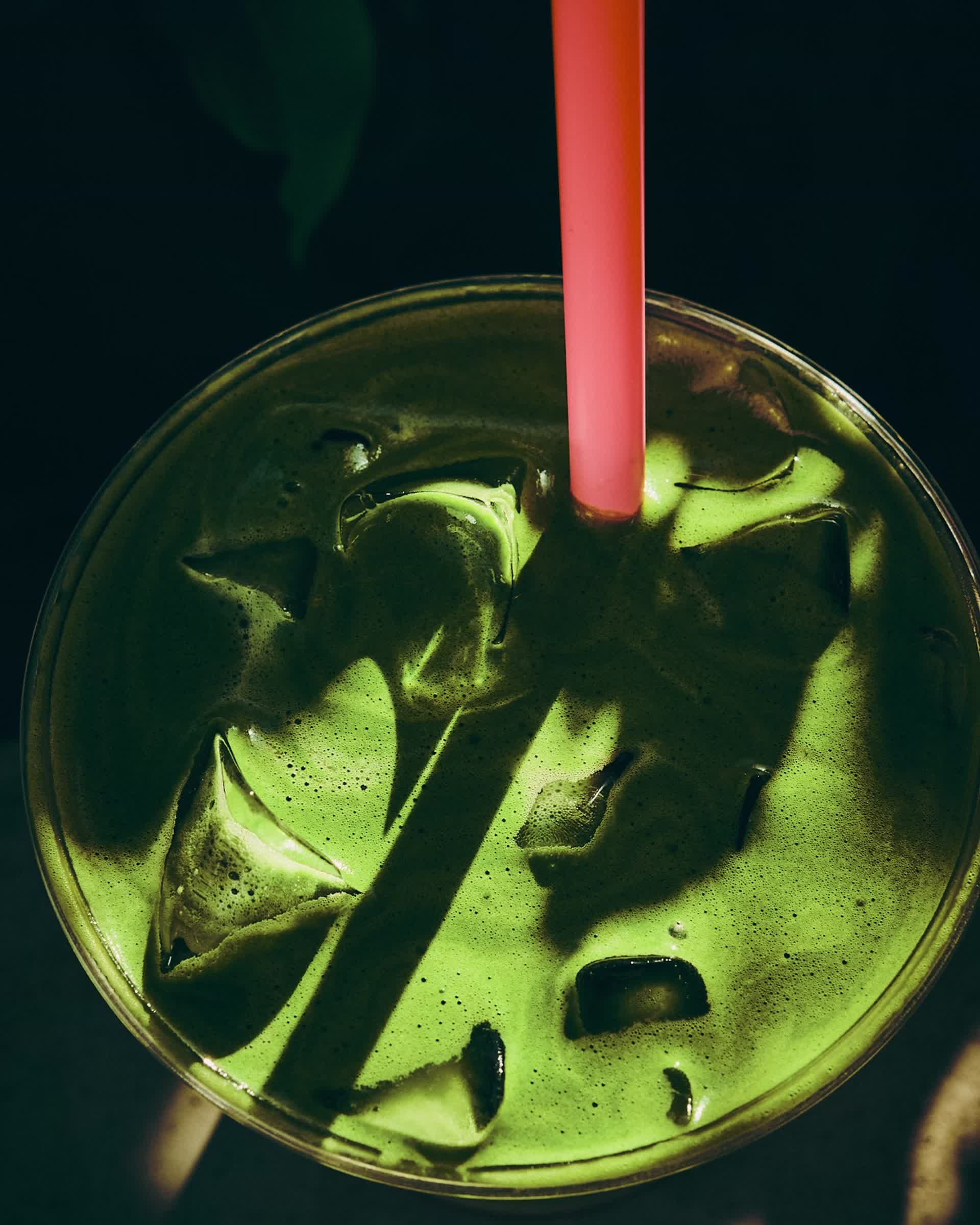 An iced Cha Cha Matcha with a pink straw, top-down