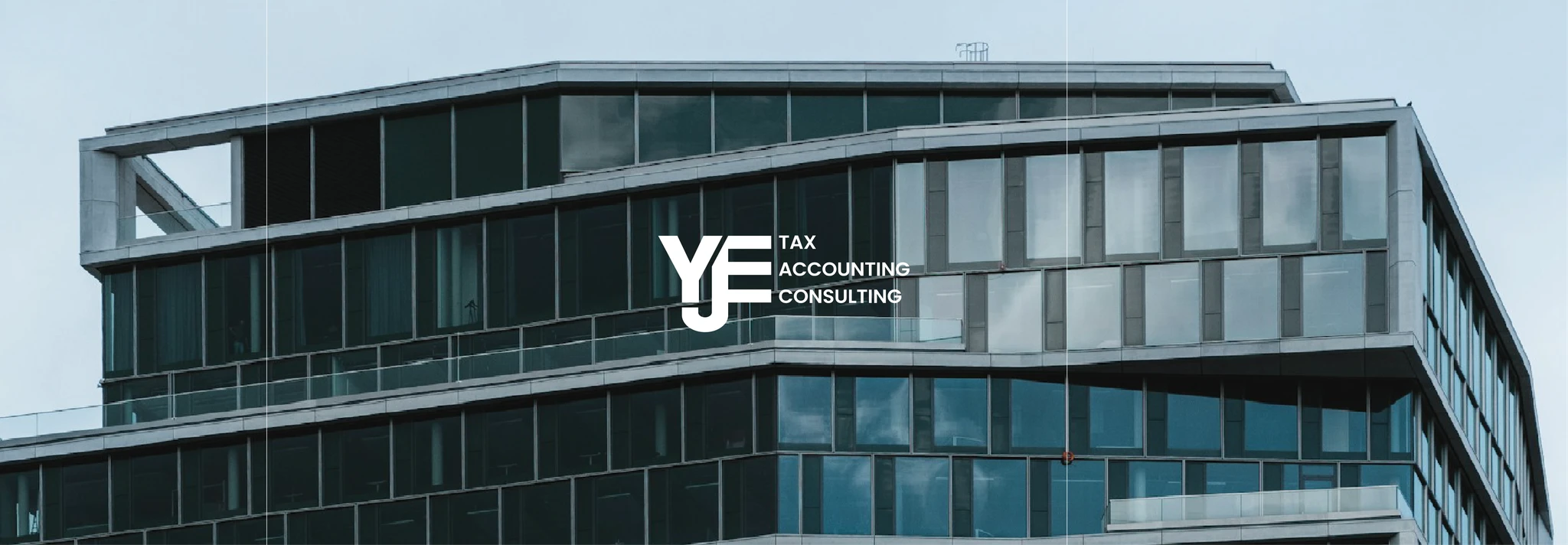 Modern building with glass windows, featuring the logo "YJ Tax Accounting Consulting".