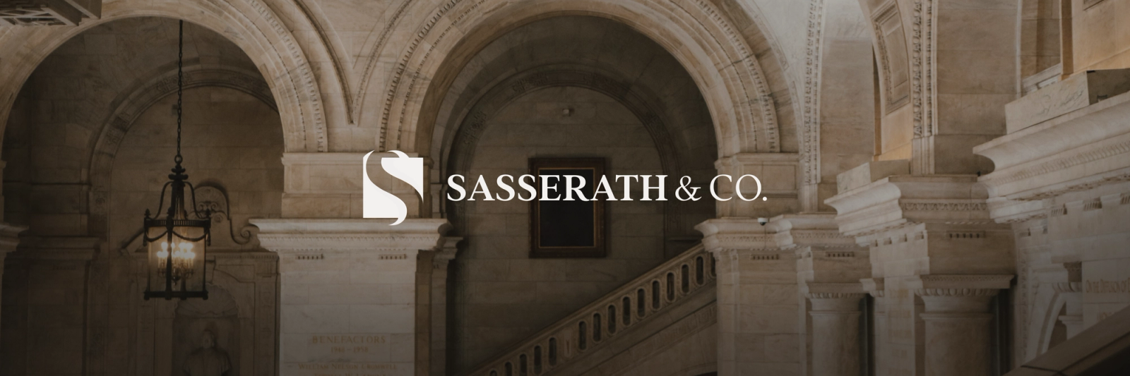 The Sasserath & Co. logo and text overlaid on a grand, ornate stone interior with arches, columns, and a staircase.