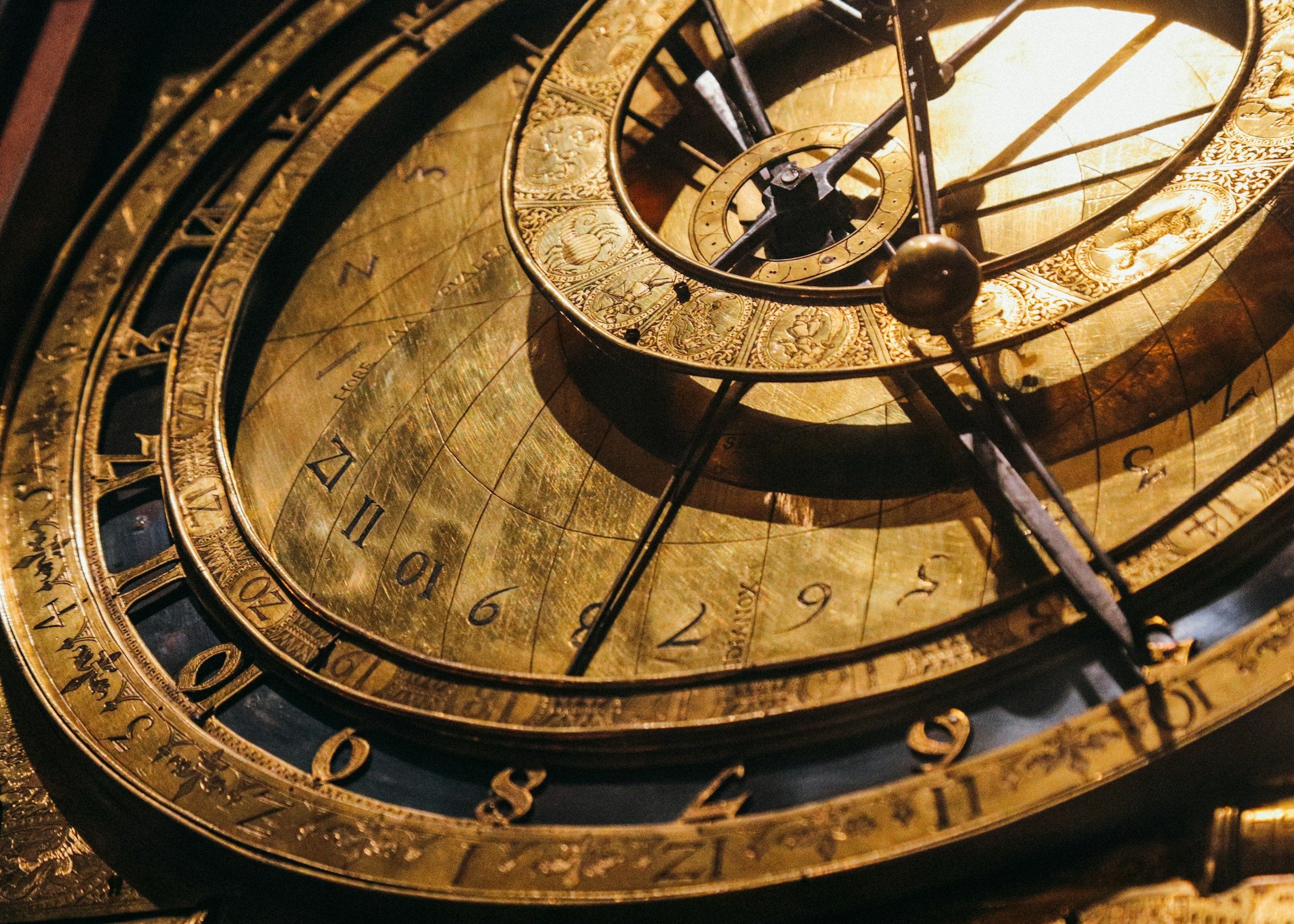 Een oud koperen astronomisch instrument met ringen en cijfers