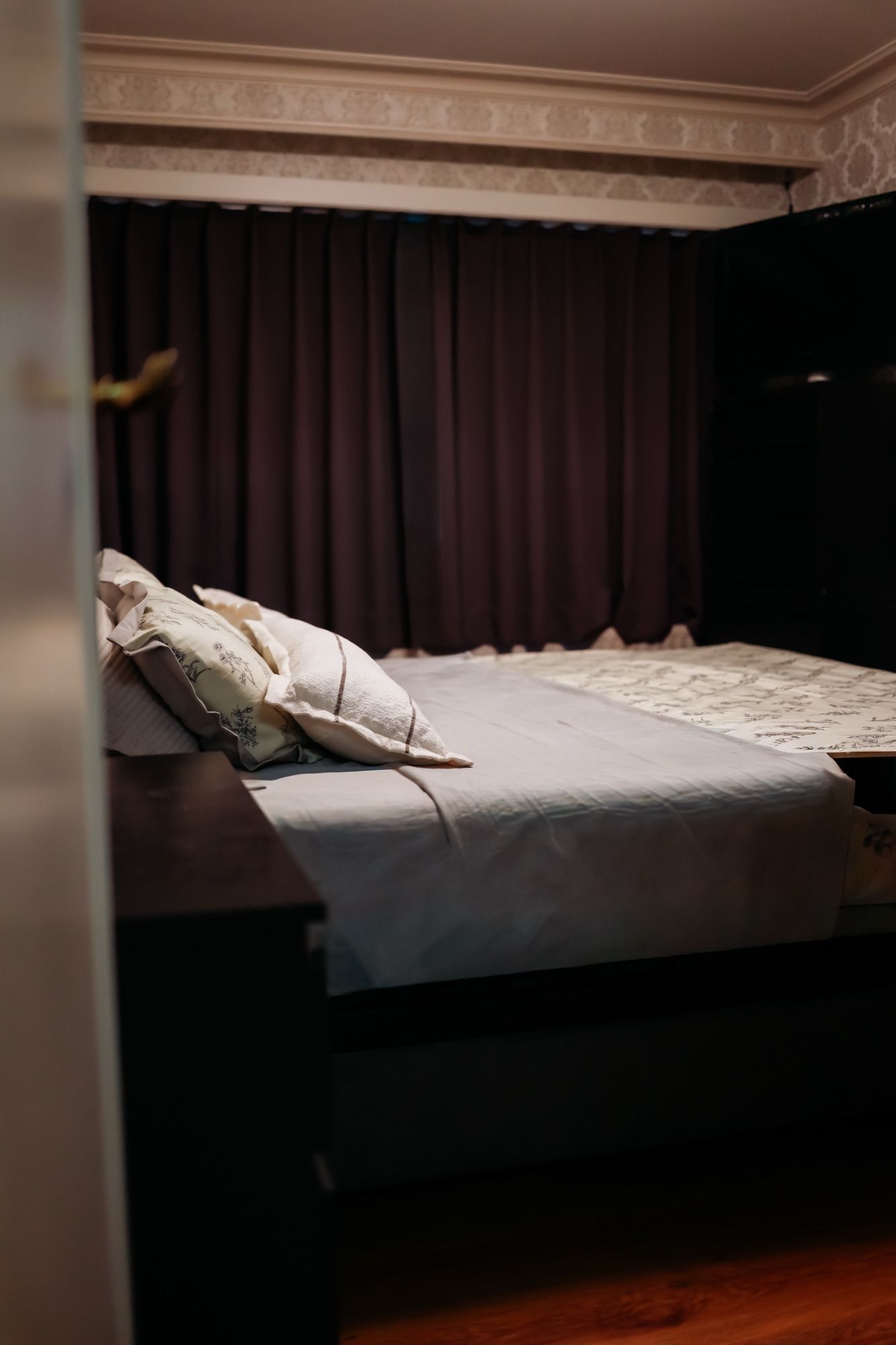 Het opgemaakte tweepersoonsbed in de aparte slaapkamer