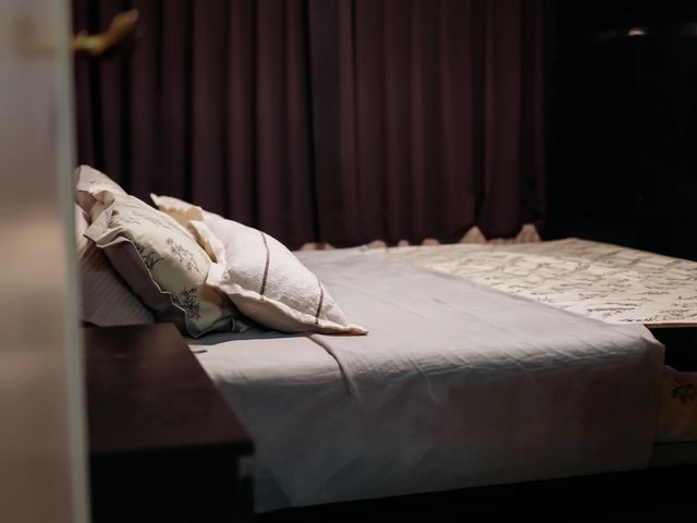 Het opgemaakte tweepersoonsbed in de aparte slaapkamer