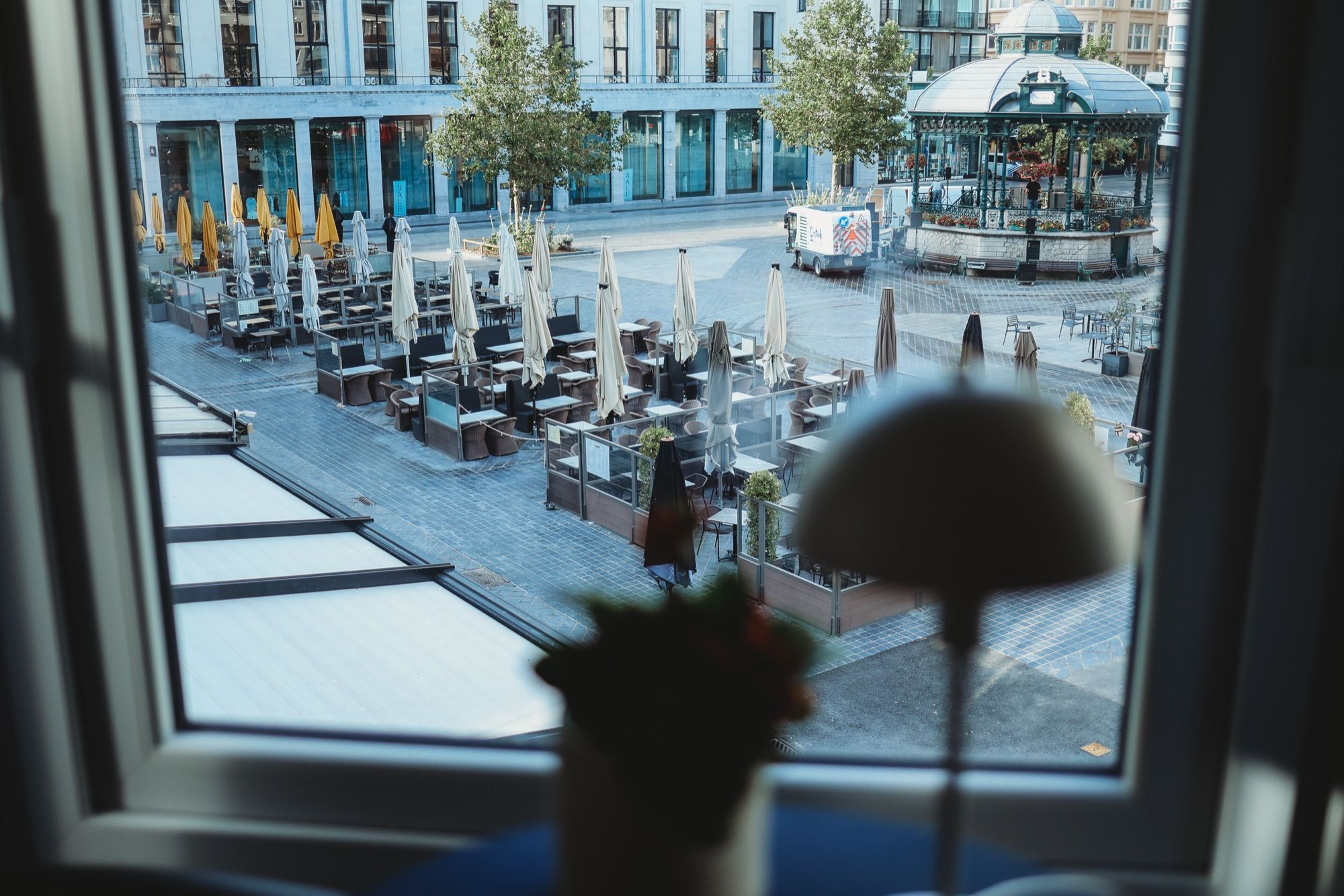 De terrassen en de kiosk op het Wapenplein, gezien door het raam van de leefruimte