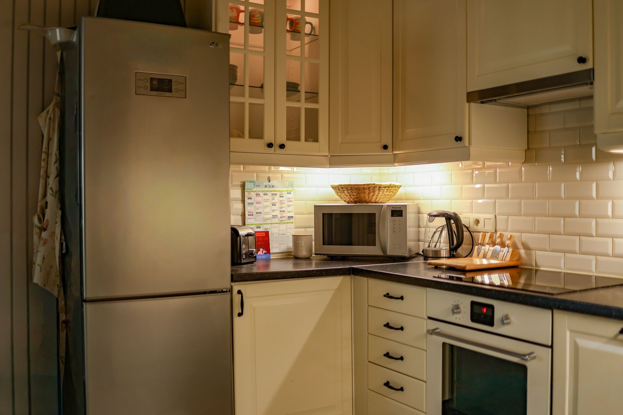 De keuken met koelkast, oven en microgolfoven