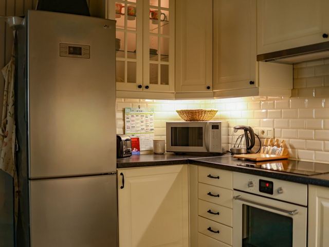 De keuken met koelkast, oven en microgolfoven