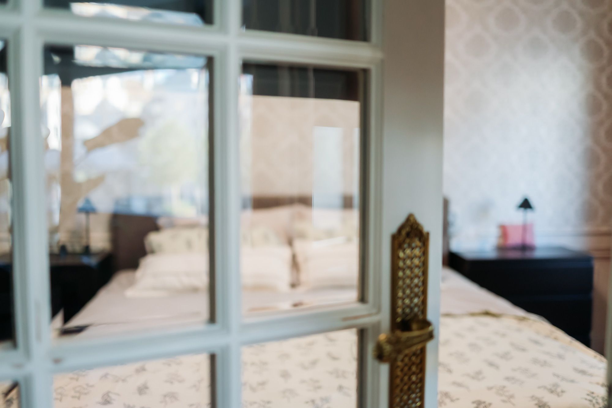Het bed achter de glazen binnendeur van de slaapkamer