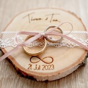 Zwei Eheringe auf einer Holzscheibe — finale Abstimmung vor der Hochzeit