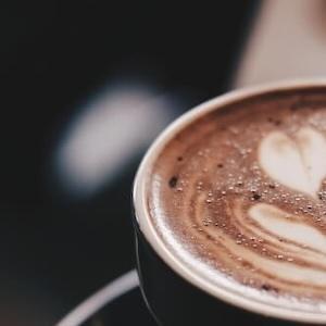 Tasse Kaffee mit schöner Latte-Art — Symbol für das lockere Kennenlerngespräch