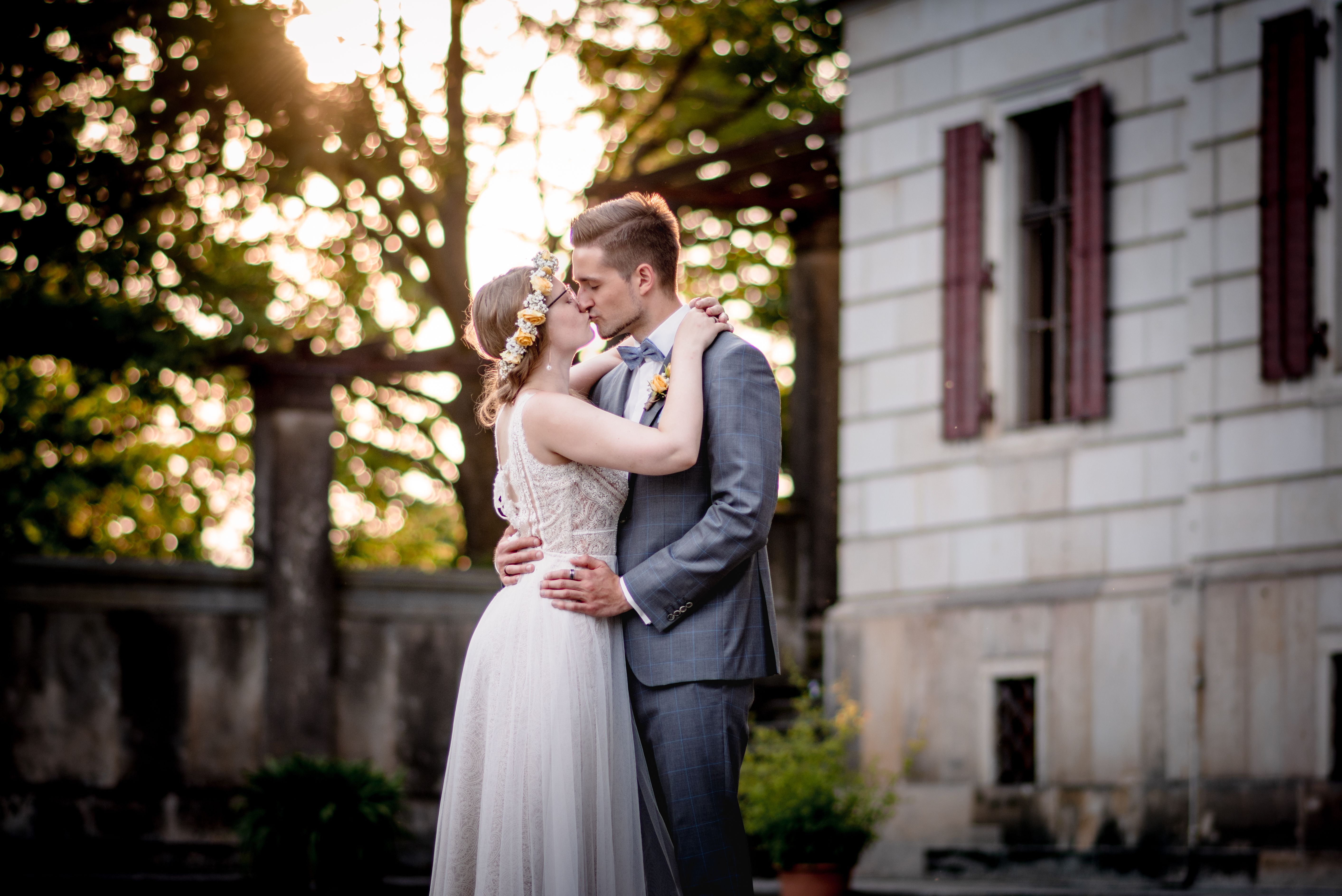 Brautpaar sitzt romantisch im Grünen — After-Wedding-Shooting
