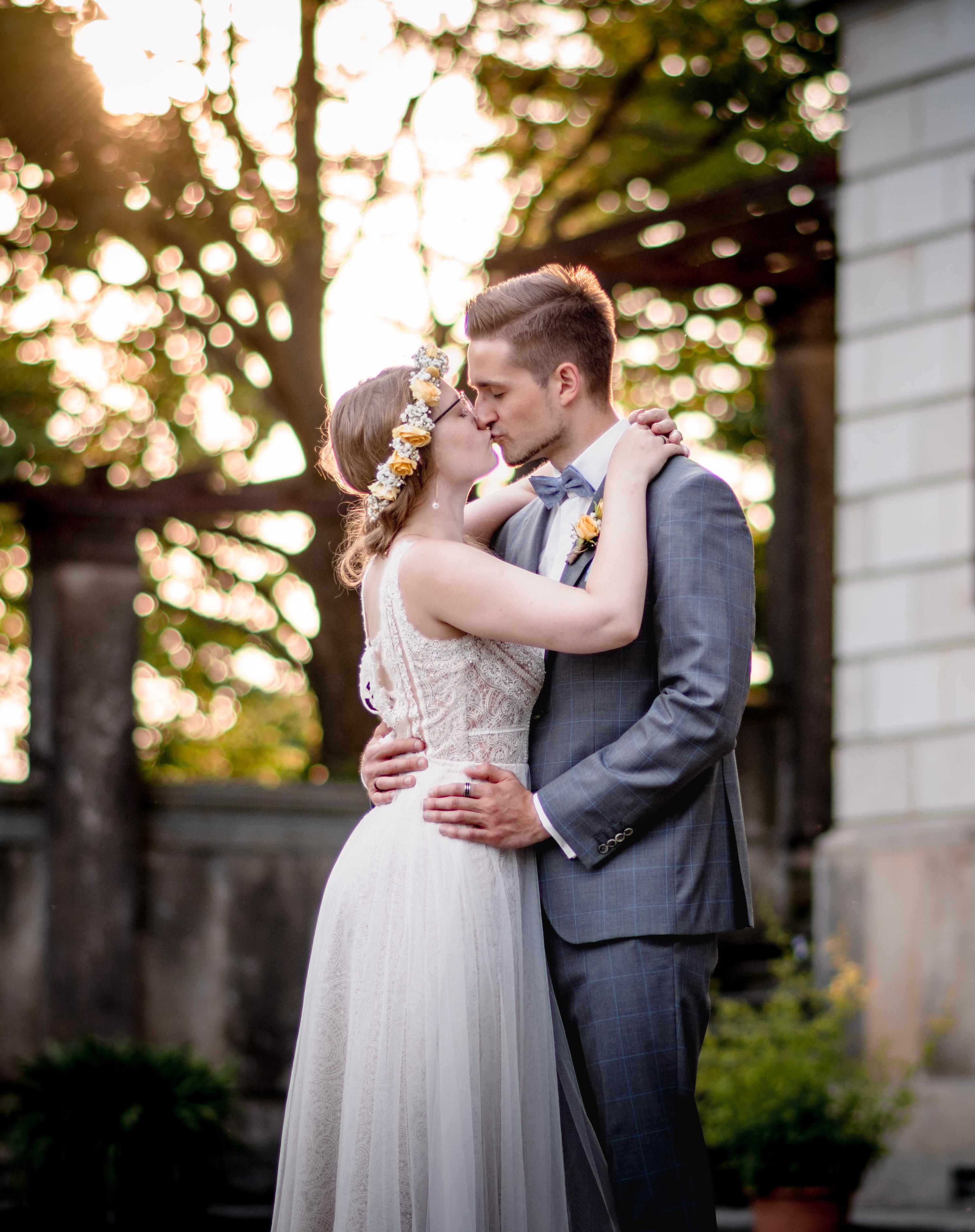 Brautpaar sitzt romantisch im Grünen — After-Wedding-Shooting