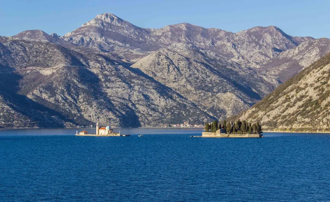 A stunning view of the two famous islets off the coast of Perast, Our Lady of the Rocks and St. George, in the serene blue waters of Boka Bay.