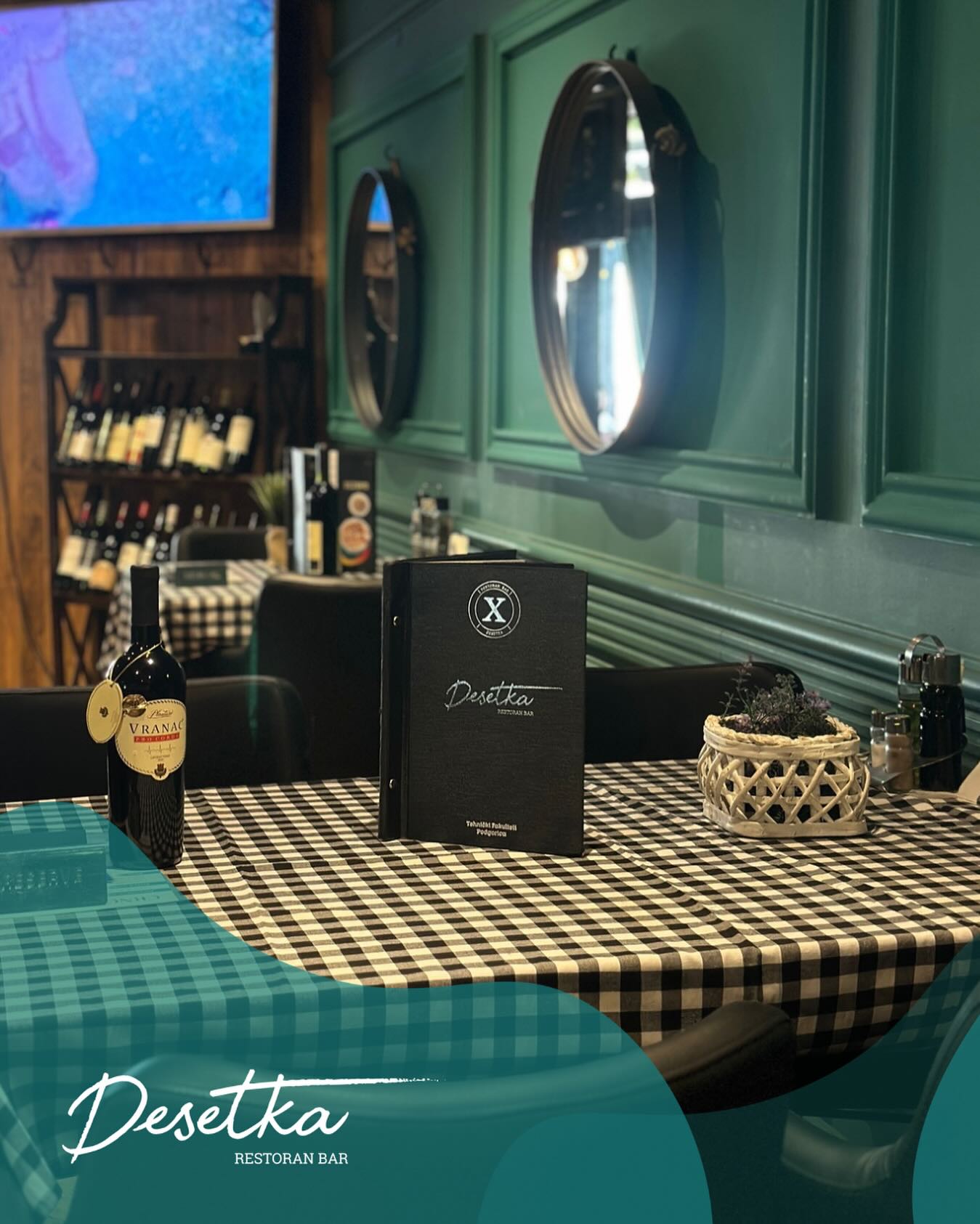 A cozy dining area in Desetka featuring a brown leather booth, checkered flooring, and artistic window displays.