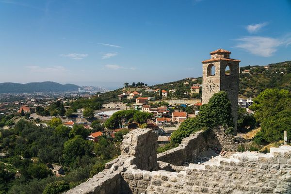 View from the ruins of Stari Bar (Old Bar), Montenegro, featuring the historic stone clock tower, with the modern city and the sea in the distance