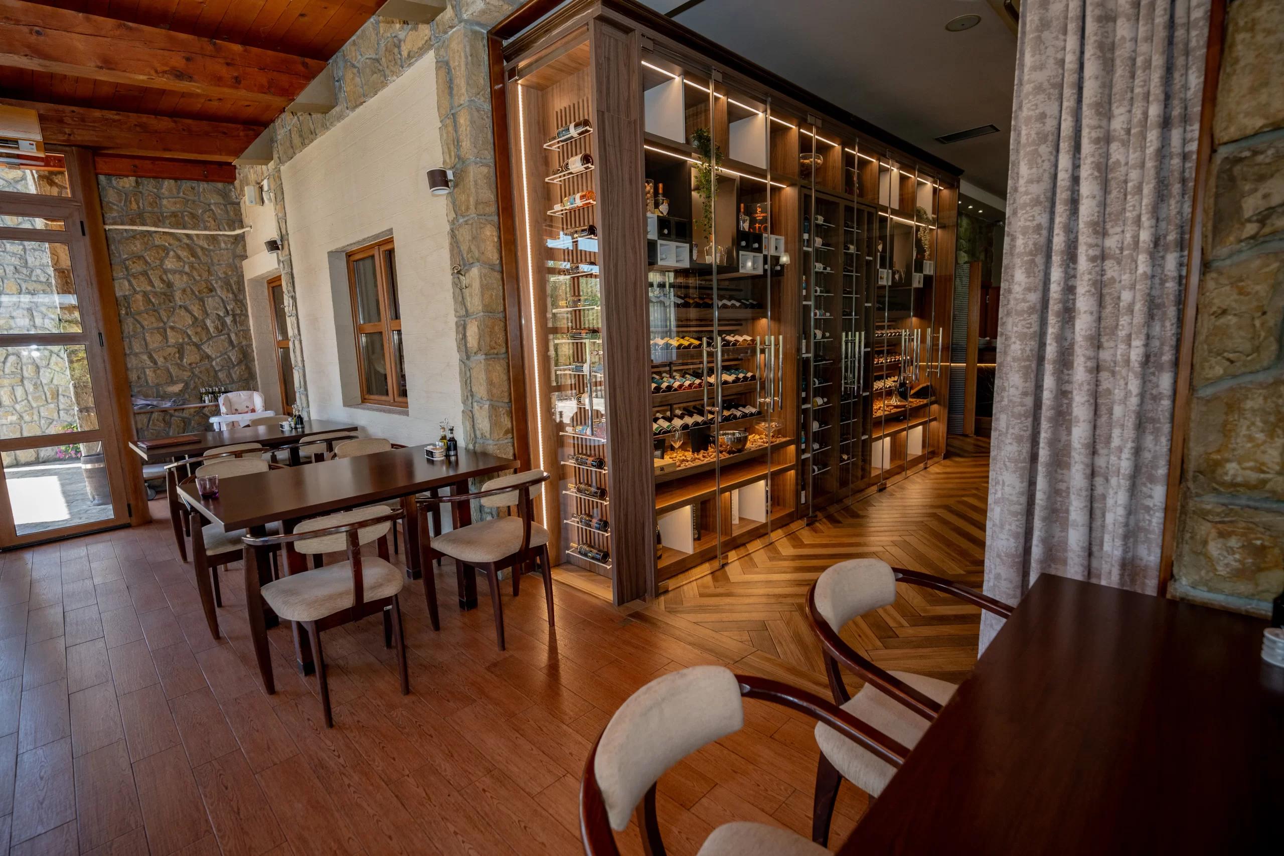 The stylish interior of the Hotel Aria restaurant, featuring a modern, floor-to-ceiling glass and wood wine cellar.