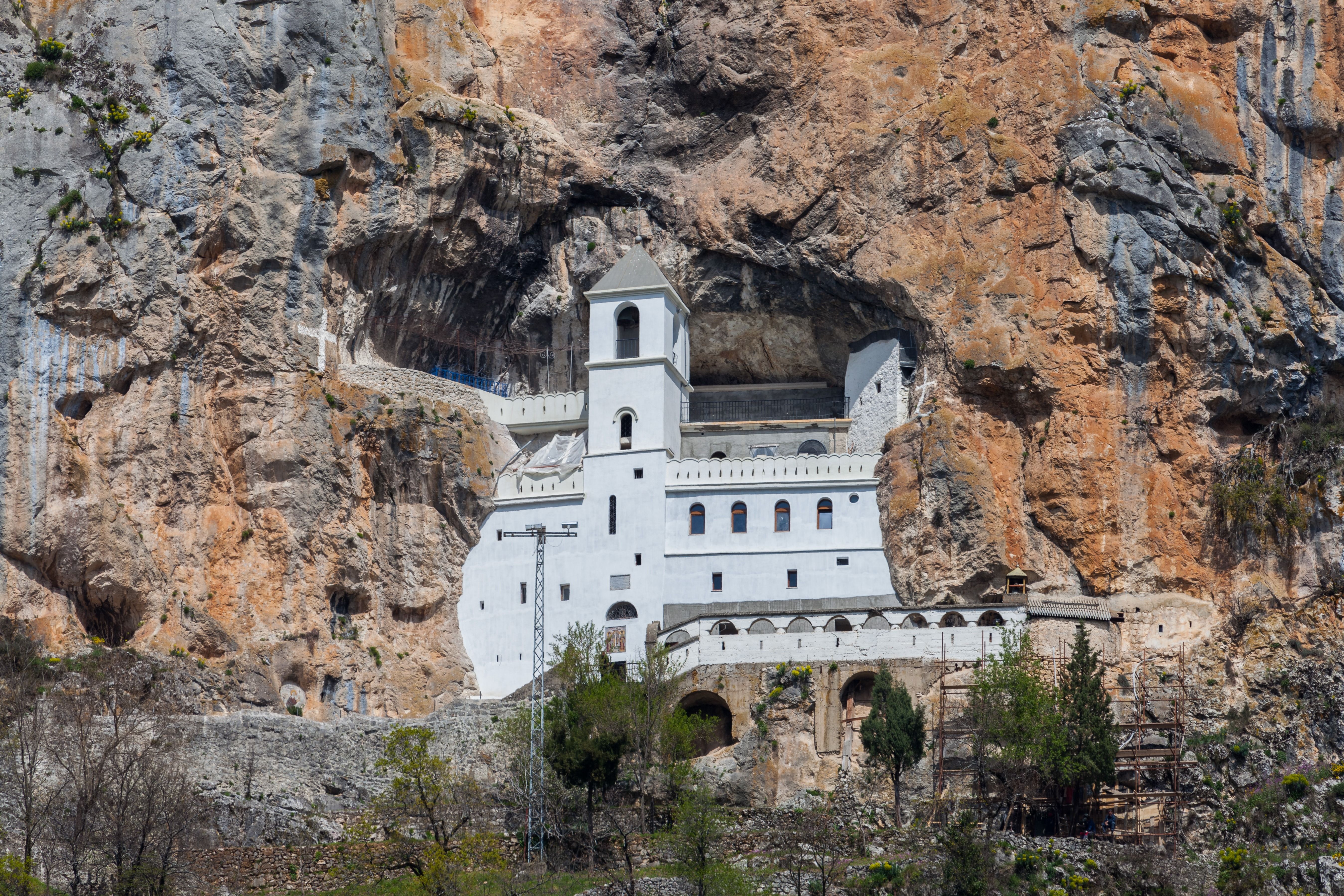 The white Ostrog Monastery built dramatically into a sheer rock cliff in Montenegro.