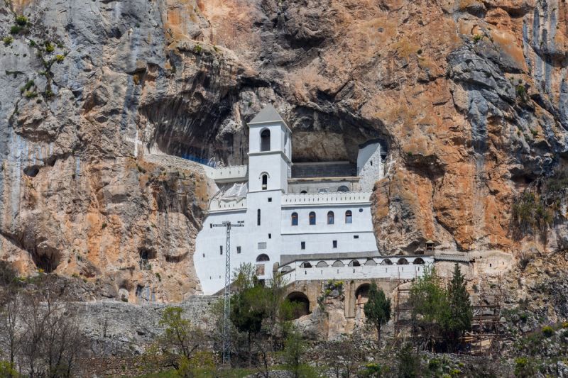The white Ostrog Monastery built dramatically into a sheer rock cliff in Montenegro.