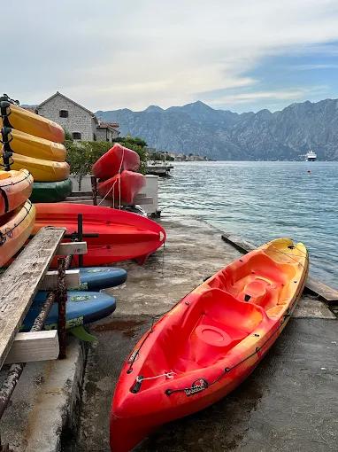 A collection of colorful kayaks stacked on a dock in a serene corner of Boka Bay, ready for the next adventure.