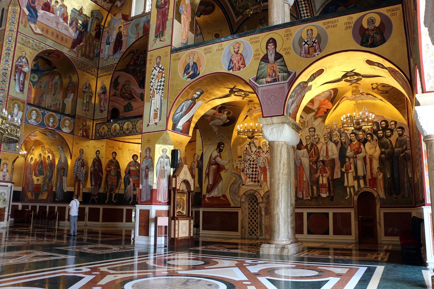The magnificent golden interior of the Cathedral, with floor-to-ceiling frescoes, marble columns, and ornate chandeliers.
