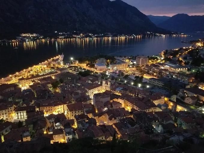 Night view of Kotor's Old Town and the illuminated bay, the historic setting where the Maximus nightclub is located.