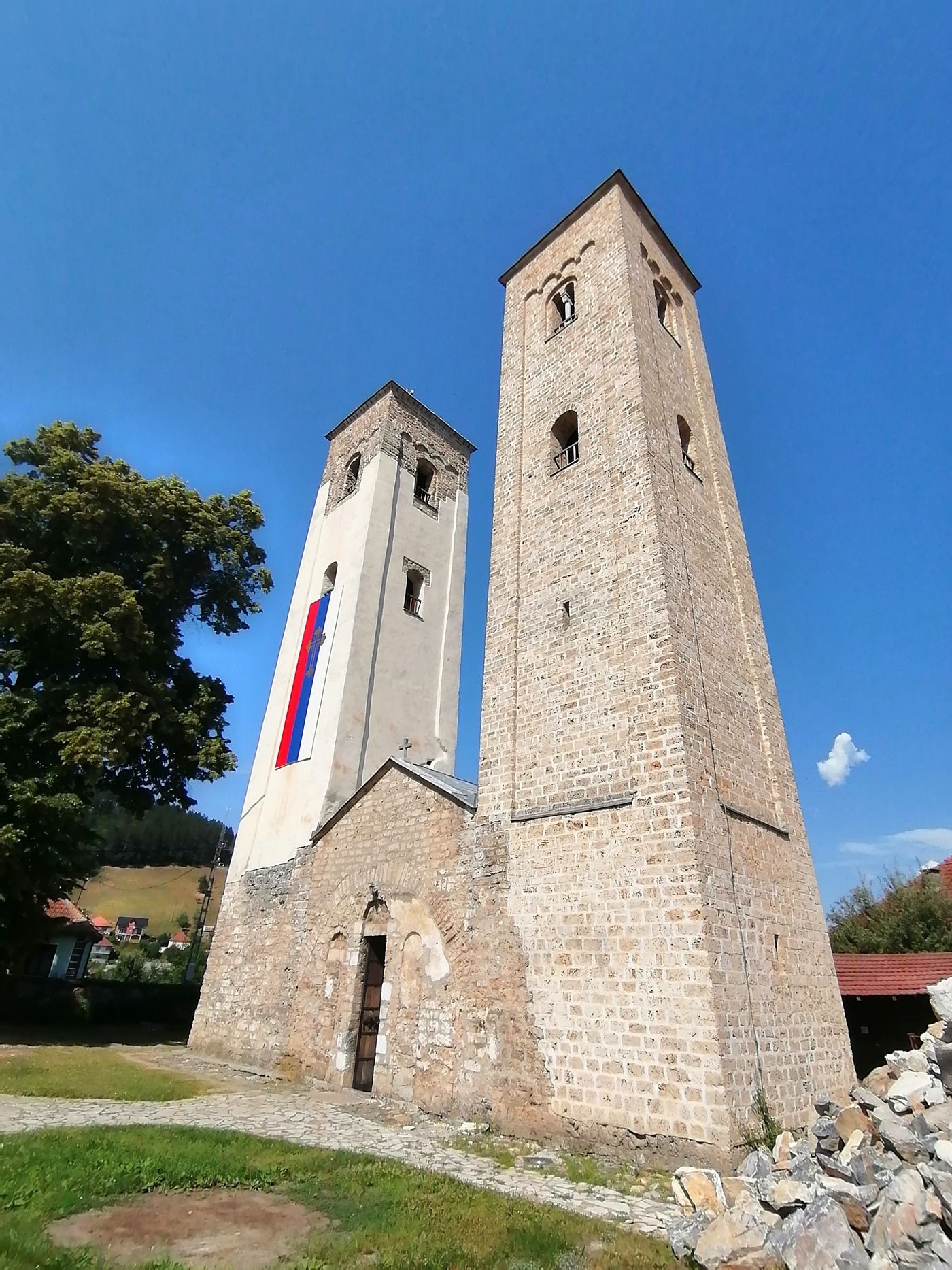 A wide, low-angle view of the medieval Church of Saints Peter and Paul and its two towers.