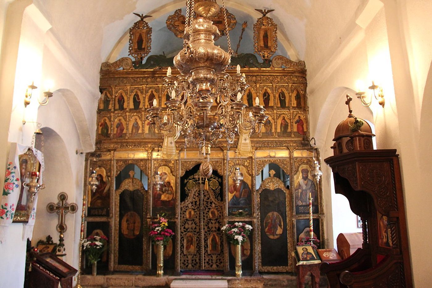 The ornate golden iconostasis and a large chandelier inside the main church of the Cetinje Monastery.