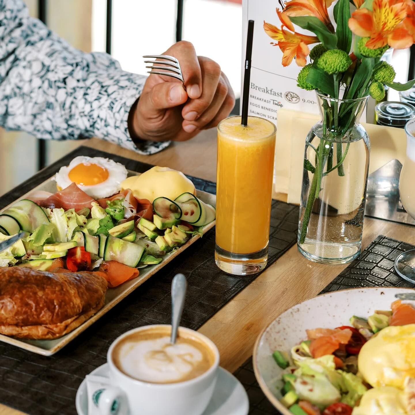 A collection of colorful summer cocktails on a table with a bar menu in the background.