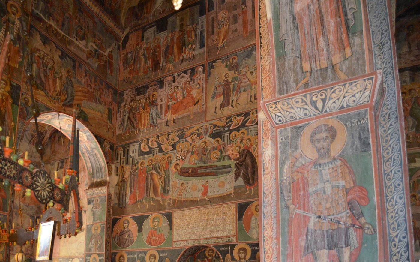 Richly detailed and colorful medieval frescoes covering the interior walls and arches of the Piva Monastery.