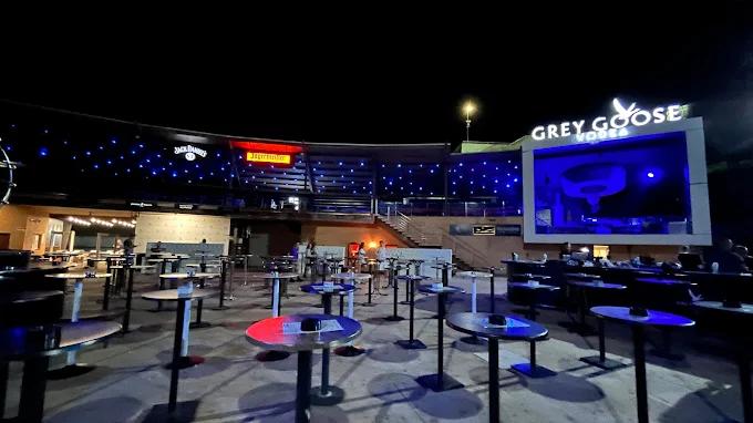 Top Hill 夜总会露天区域的广角视图，展示了其多层结构、桌子和派对高峰前的大舞台。