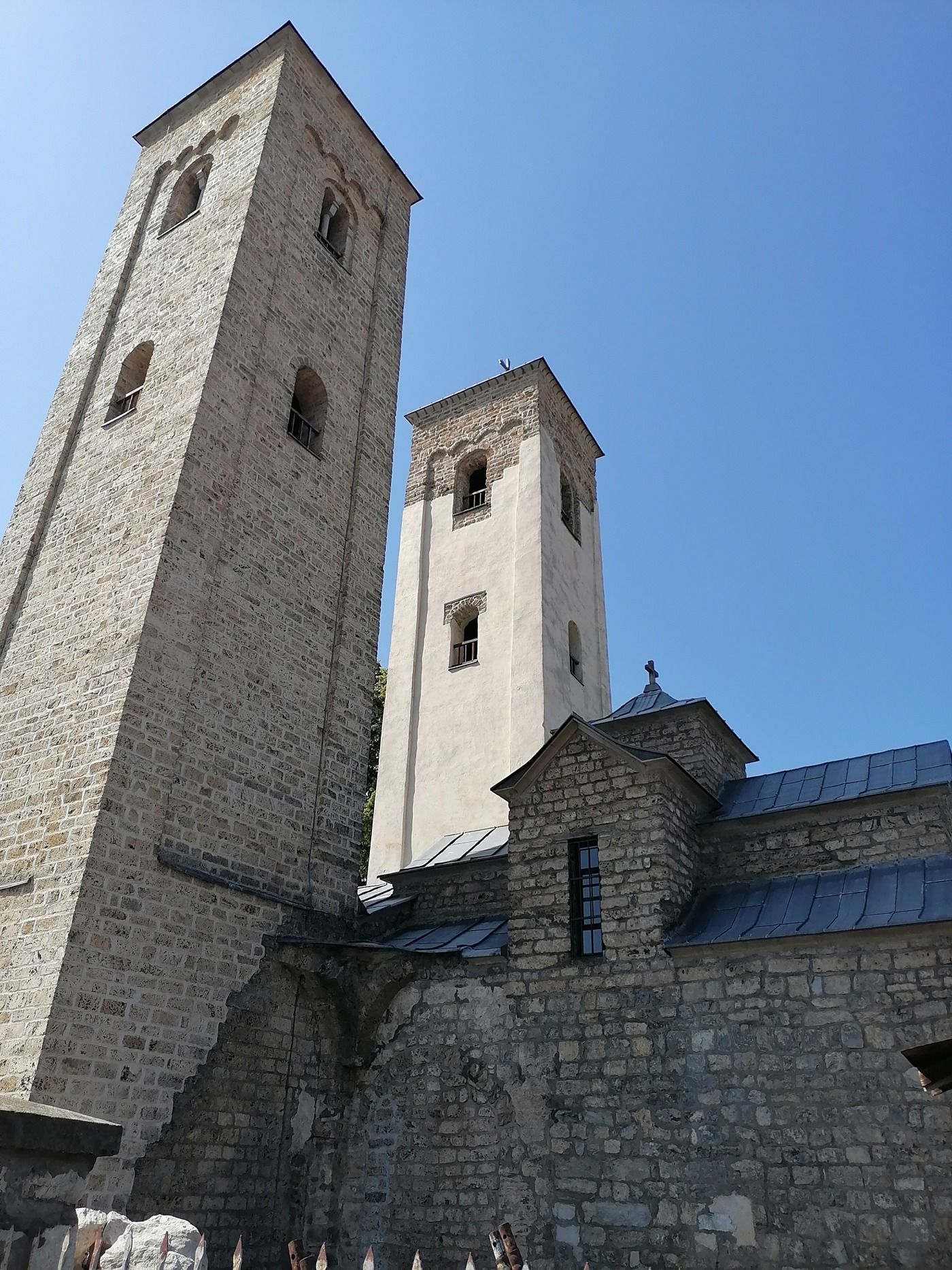 A low-angle view looking up at the two stone bell towers of the Church of Saints Peter and Paul.