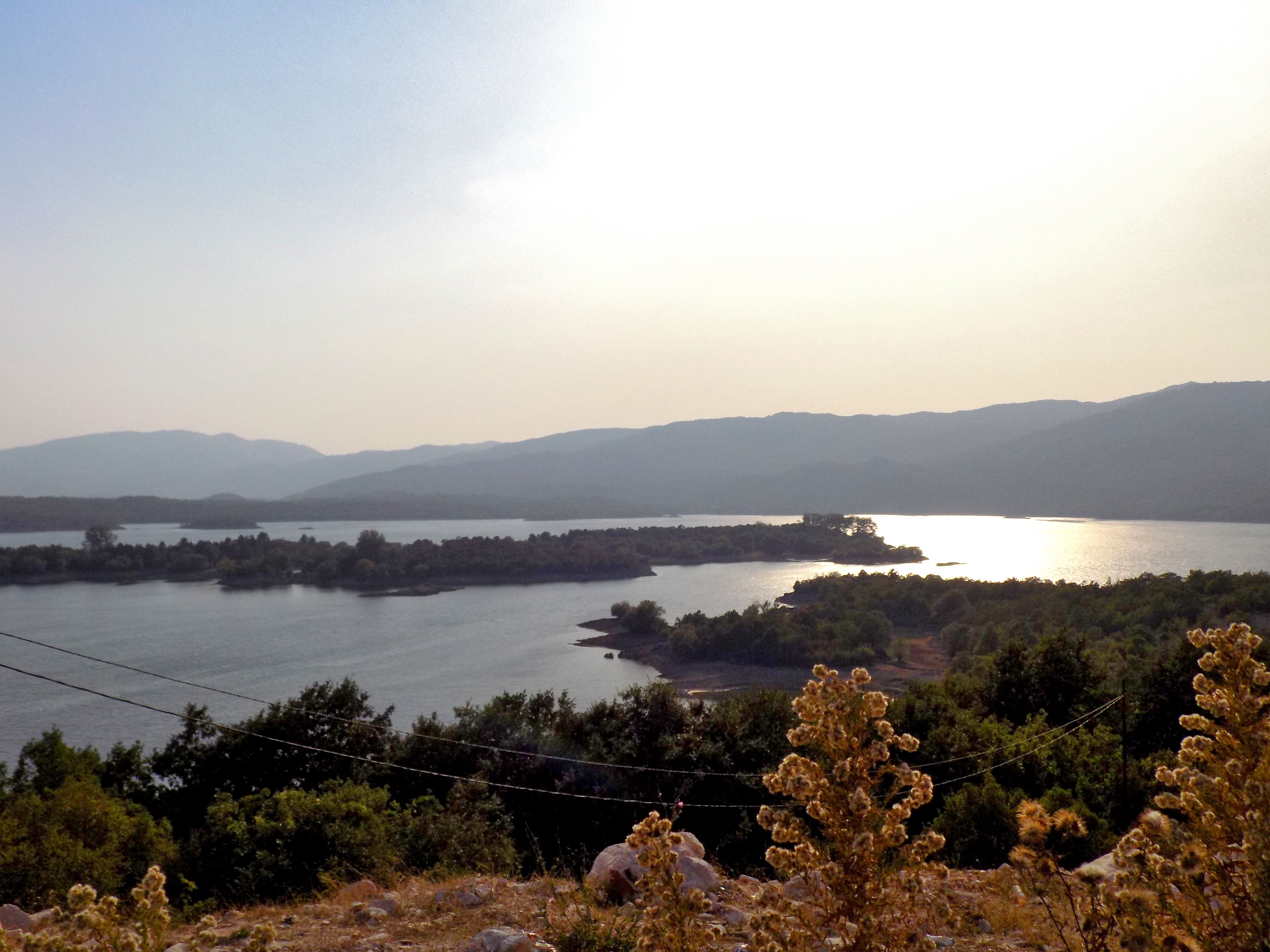 A scenic view of Lake Krupac at sunset, with light reflecting on the water and its islands.