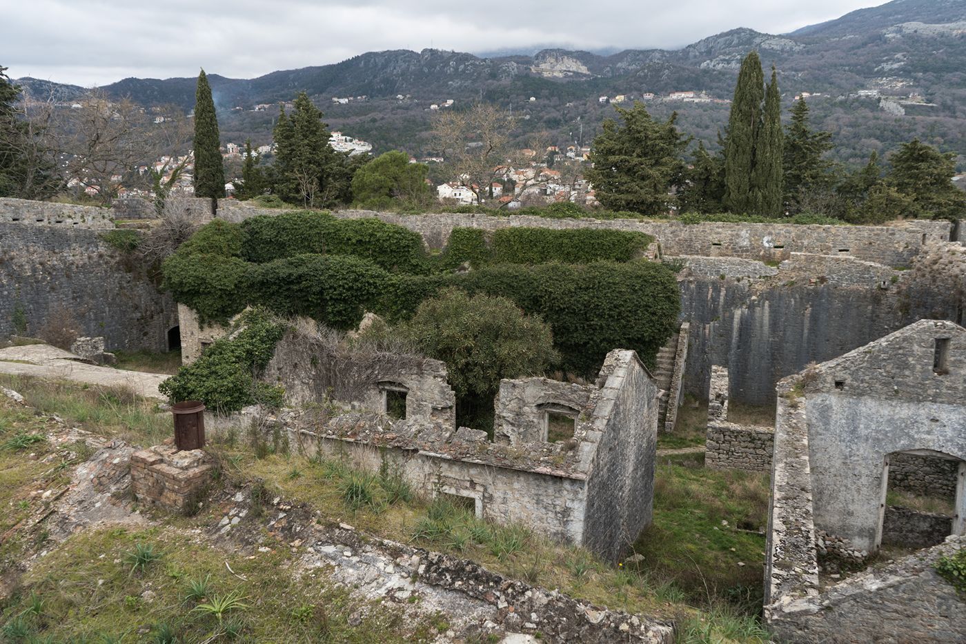 The overgrown stone ruins of the historic Španjola Fortress on a hill above Herceg Novi, Montenegro.