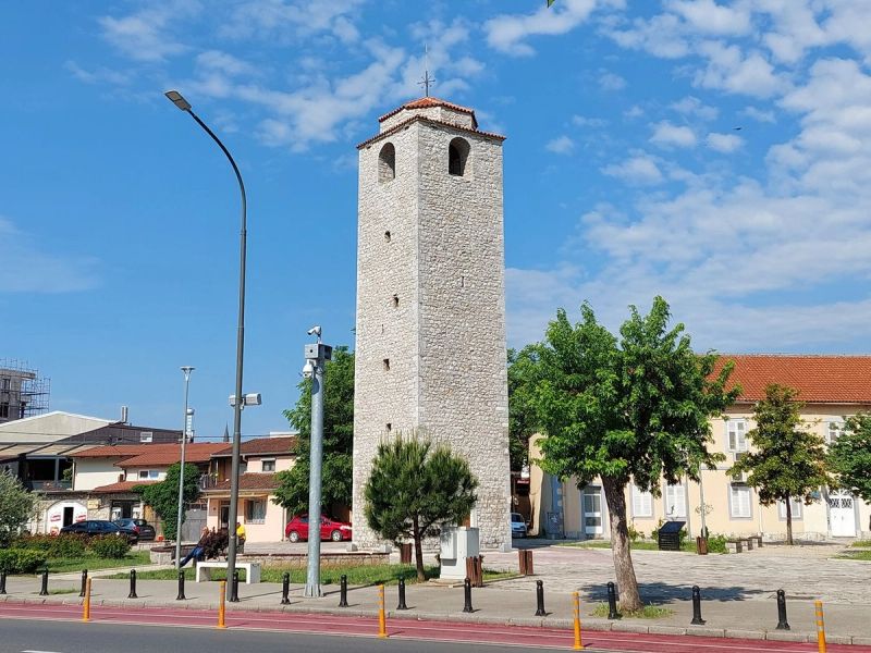 The old stone Clock Tower (Sahat Kula) in Podgorica against a blue sky.