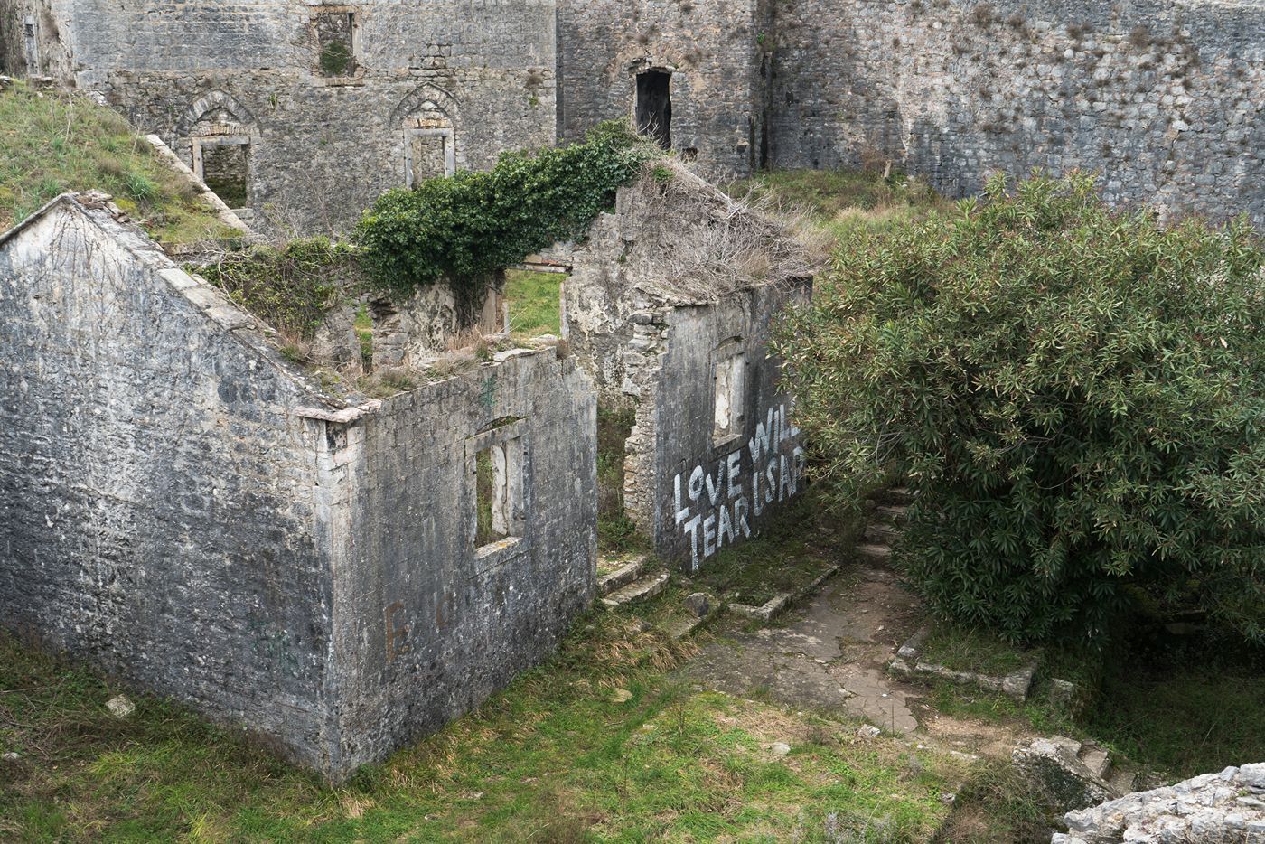 A close-up of the decaying walls inside Španjola Fortress, with poignant graffiti visible.