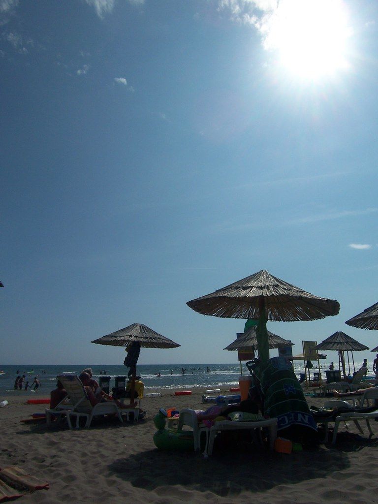 A sunny day on Velika Plaža, with thatched umbrellas and sun loungers looking out towards the sea.
