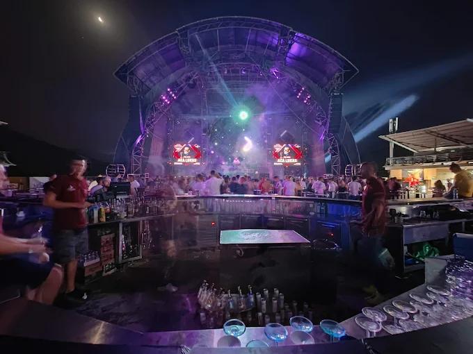 Top Hill 夜总会主舞台的夜间全景，从吧台后方可以看到充满活力的灯光秀、大屏幕和精力充沛的人群。