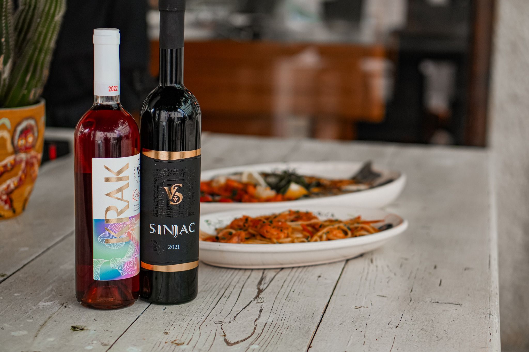 The cozy and elegant interior of Lupo di Mare restaurant, with a stone wall, warm lighting, and beautifully set dining tables.