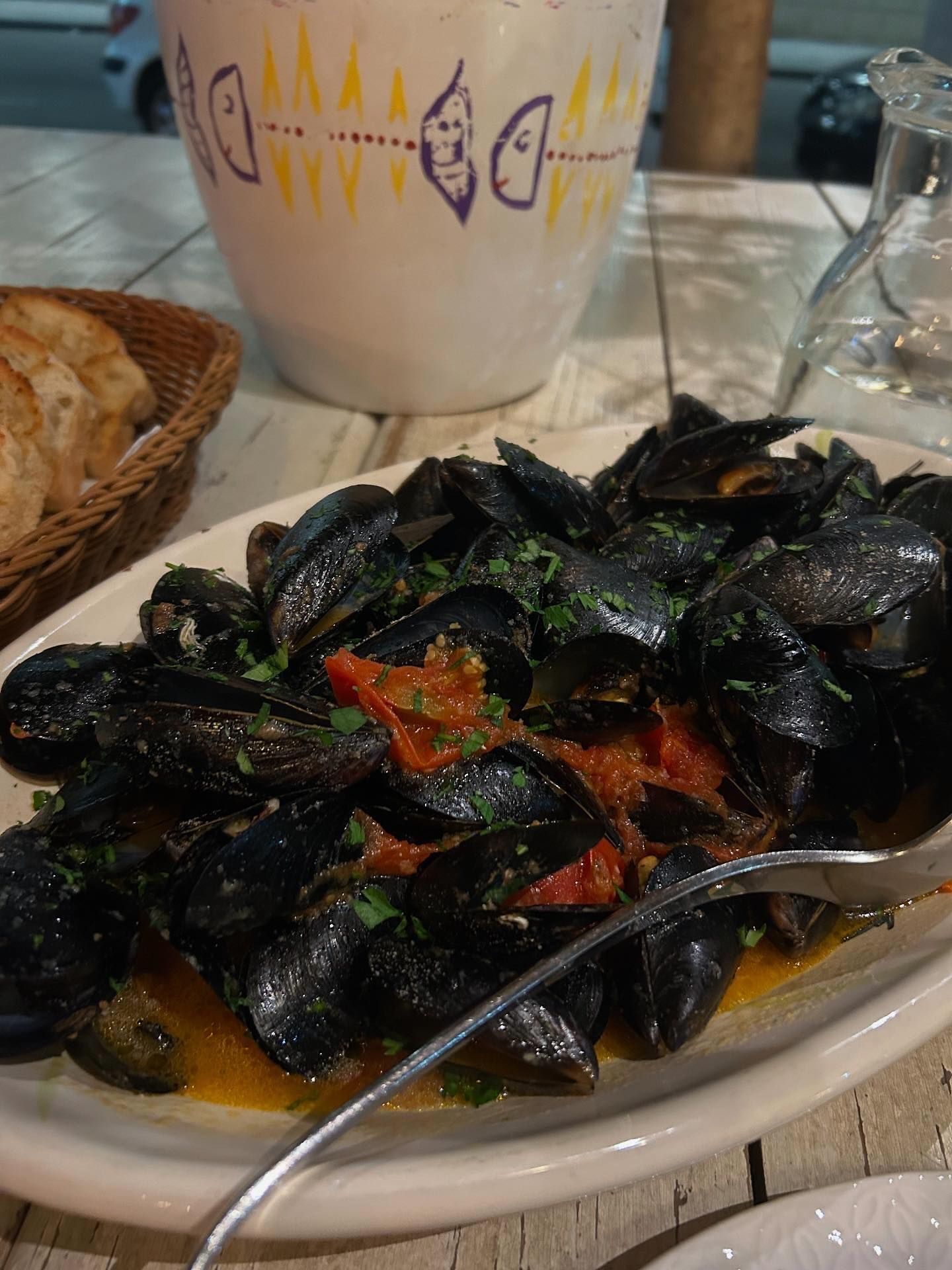 An artfully arranged seafood platter featuring grilled octopus, shrimp, and fresh fish, garnished with herbs and lemon.