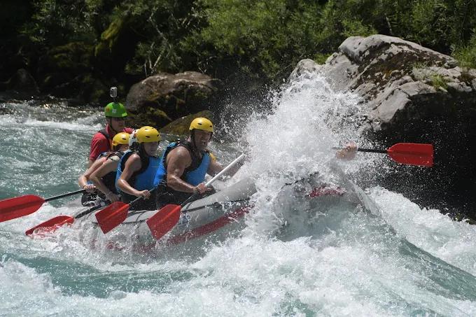 Action shot of a raft battling the intense white water rapids of the Tara River, with water splashing high.