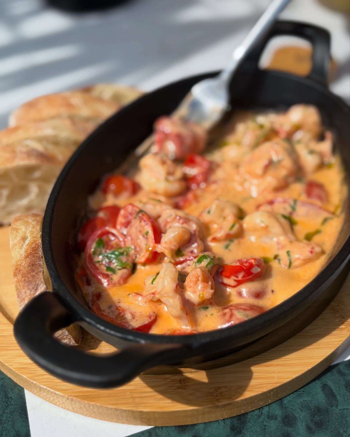 A delicious modern breakfast platter with eggs benedict, a croissant, and fresh salad, served with coffee and orange juice.