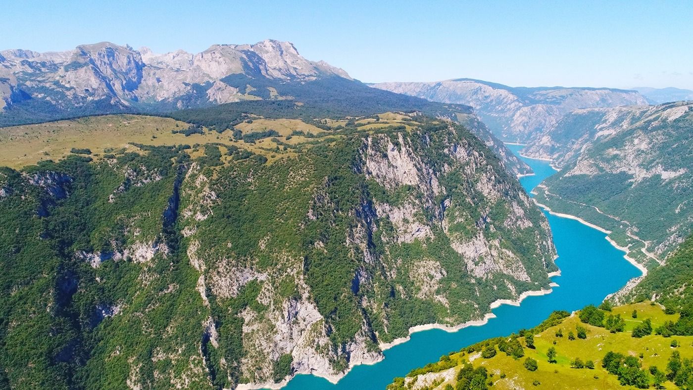 A spectacular aerial view of Piva Lake, with its brilliant turquoise water flowing through the deep Piva Canyon.