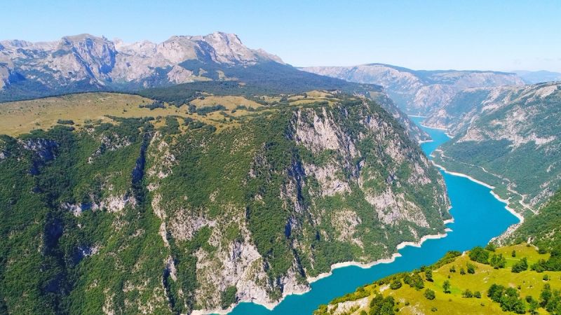 A spectacular aerial view of Piva Lake, with its brilliant turquoise water flowing through the deep Piva Canyon.