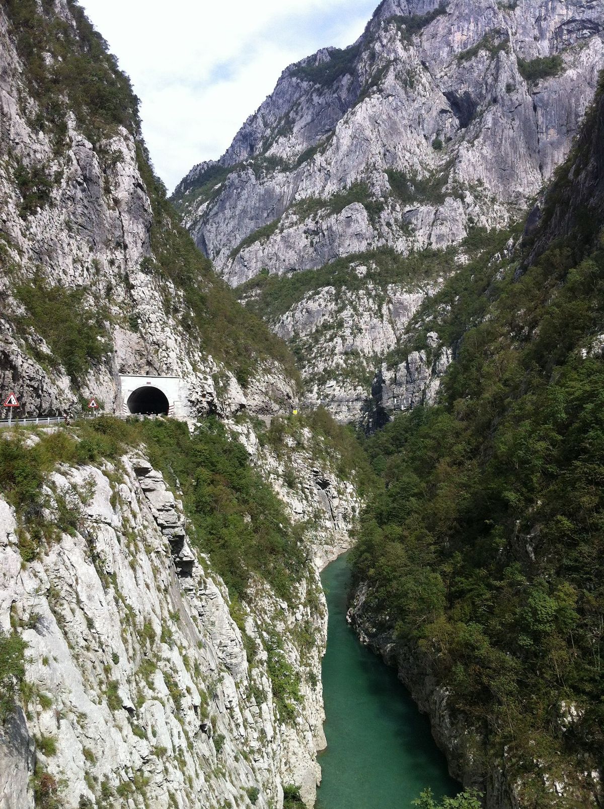 Une vue spectaculaire sur le canyon de la rivière Morača près de Kolašin, au Monténégro, montrant la rivière turquoise en contrebas et une route avec un tunnel creusé dans les falaises rocheuses abruptes