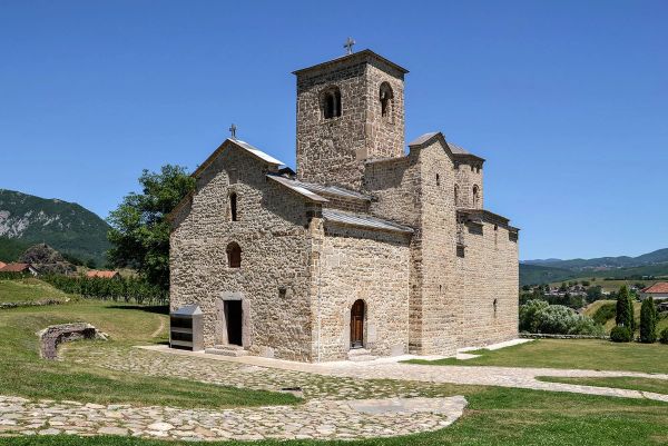 Srednjovjekovni manastir Đurđevi stupovi u Beranama, Crna Gora, istorijska kamena pravoslavna crkva sa zvonikom, koja stoji na travnatom brdu pod vedrim plavim nebom
