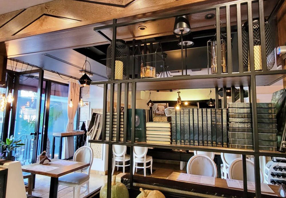 A detail of the sophisticated decor inside the Steak House, featuring shelves with books and elegant lighting fixtures.