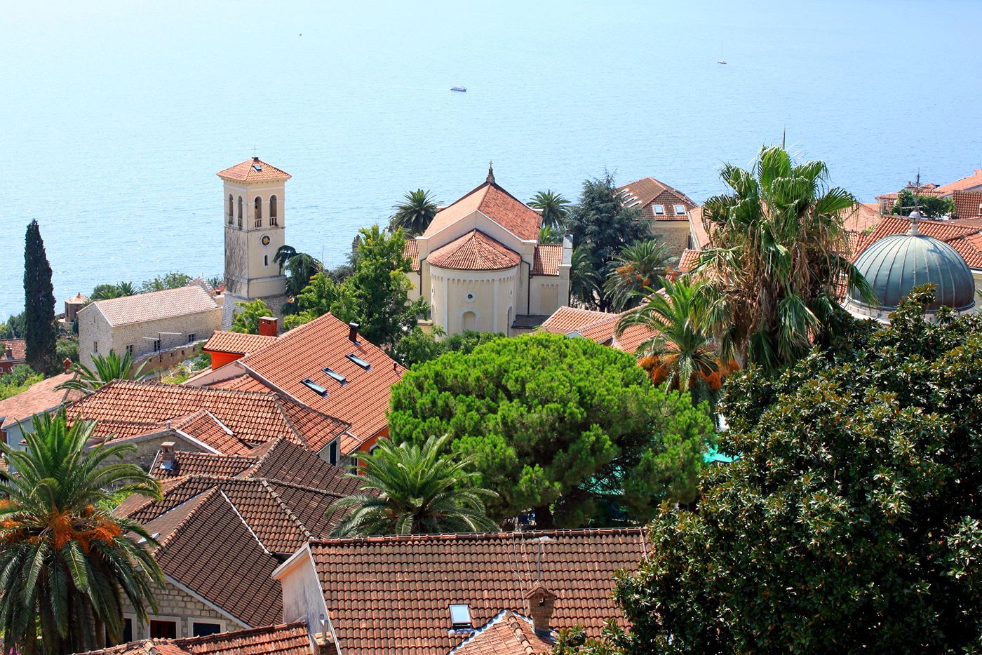 A scenic view from Kanli Kula Fortress overlooking the red-roofed Old Town of Herceg Novi and the sea.