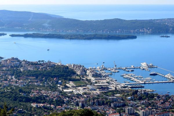 Ein Panoramablick aus der Vogelperspektive auf Porto Montenegro in Tivat, der den Luxusyachthafen voller Yachten zeigt, mit den Inseln Sveti Marko und Gospa od Milosti in der Bucht von Kotor