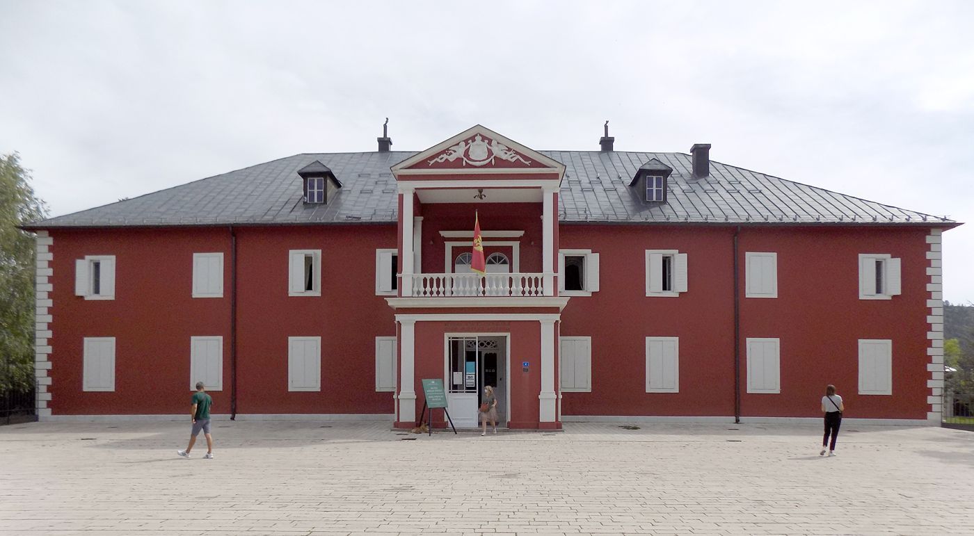 The grand red facade of King Nikola's Museum, the former royal palace in Cetinje, Montenegro.