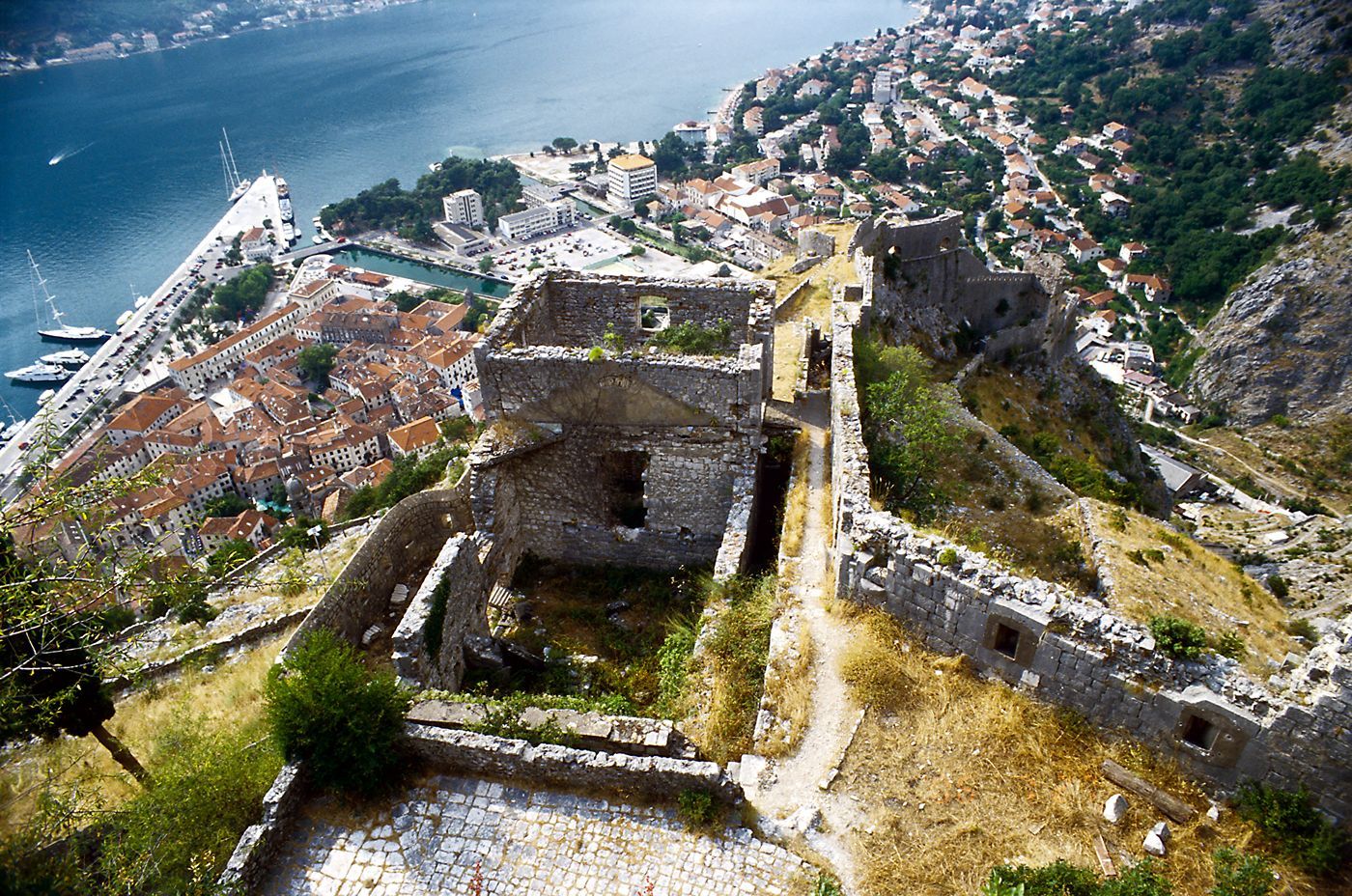 A breathtaking view from St. John's Fortress, looking down on the red roofs of Kotor's Old Town and the blue Bay of Kotor.