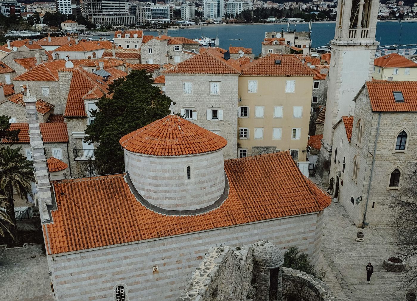 Вид с воздуха на церковь Святой Троицы, показывающий ее красную черепичную крышу и характерные полосатые каменные стены.